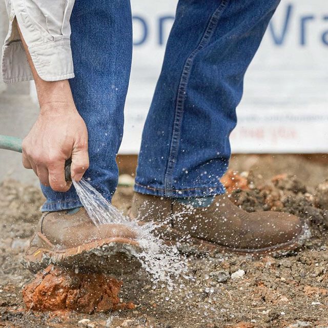 Hombre limpiando botas de trabajo impermeables sin cordones TLX Boom de 11".